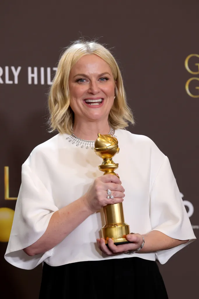 Amy Poehler holding a Golden Globe.