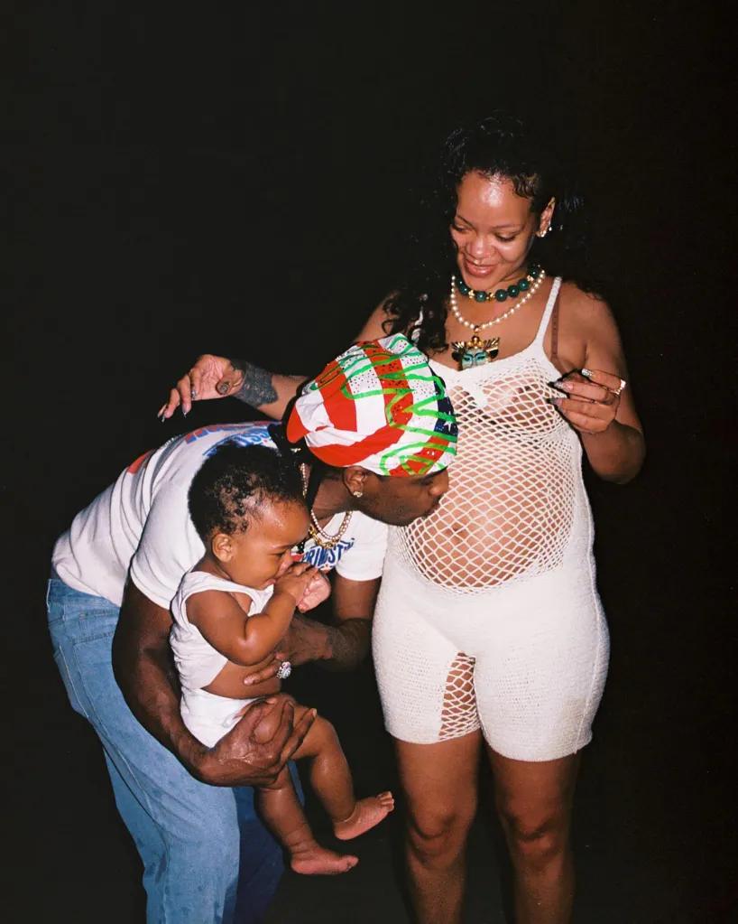 A$AP Rocky, holding a baby, and a pregnant Rihanna pose together.