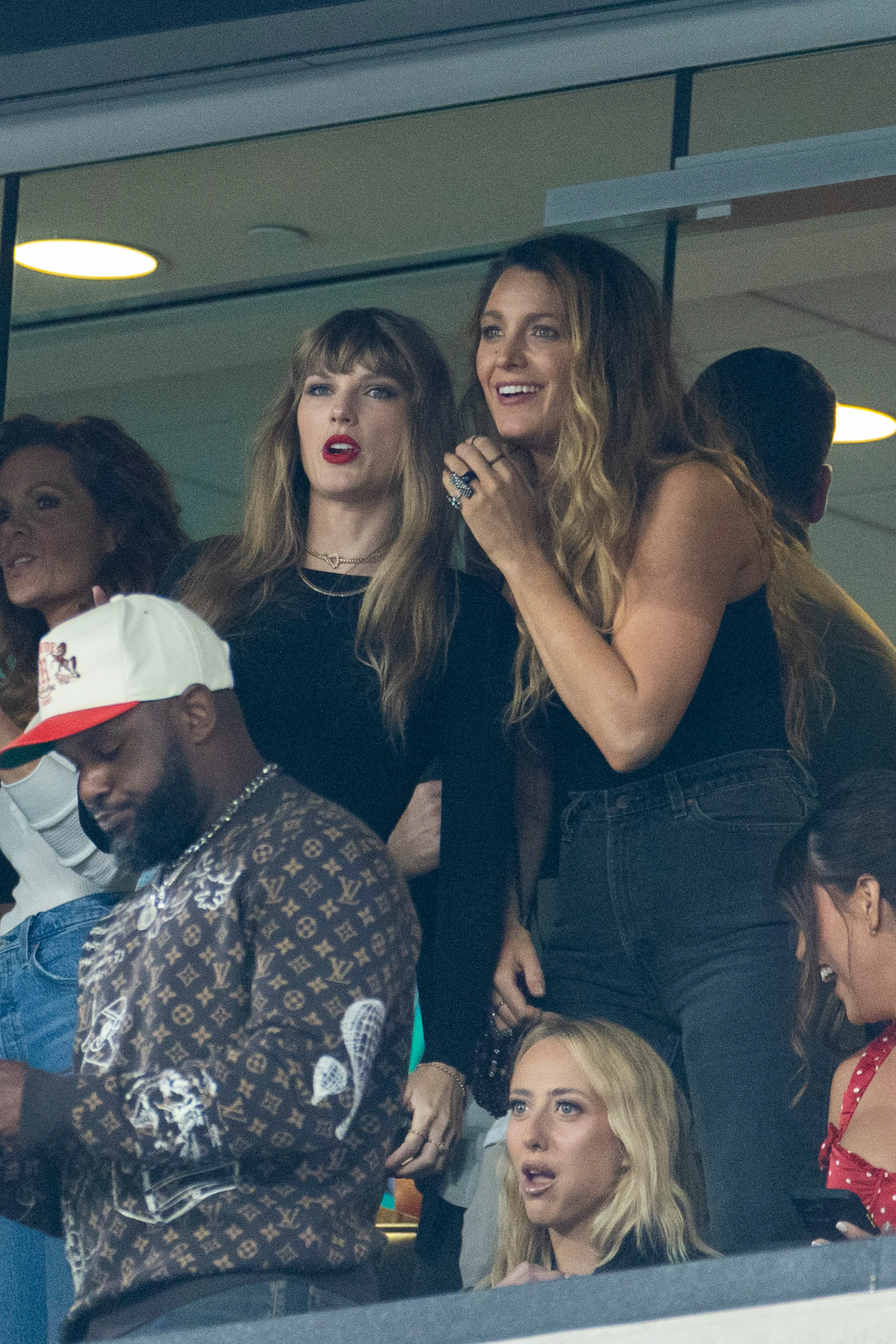Taylor Swift and Blake Lively watching a football game in a luxury box.