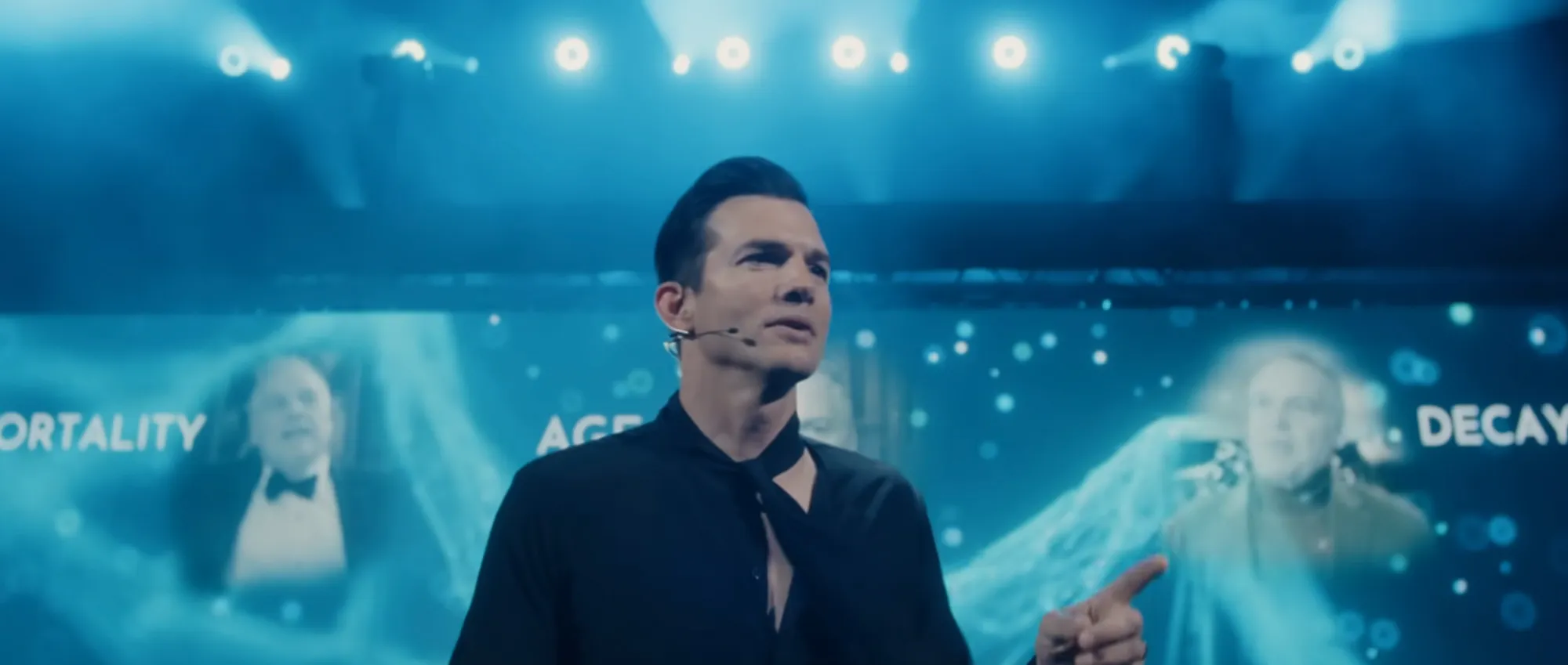 Ashton Kutcher delivering a presentation with the words 