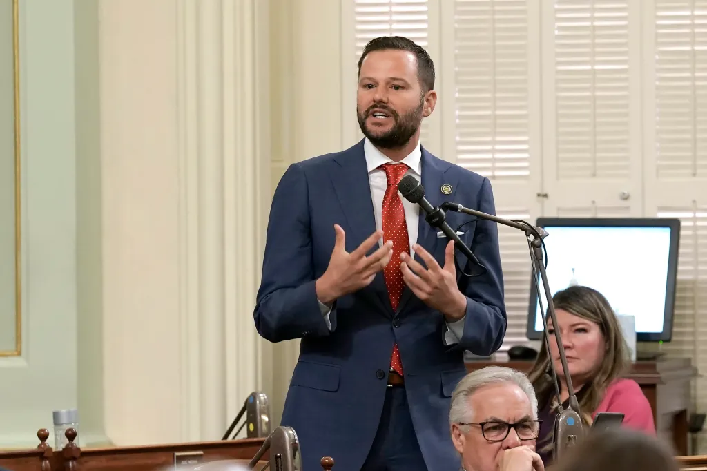 Assemblyman Matt Haney speaking at a podium in a legislative chamber.