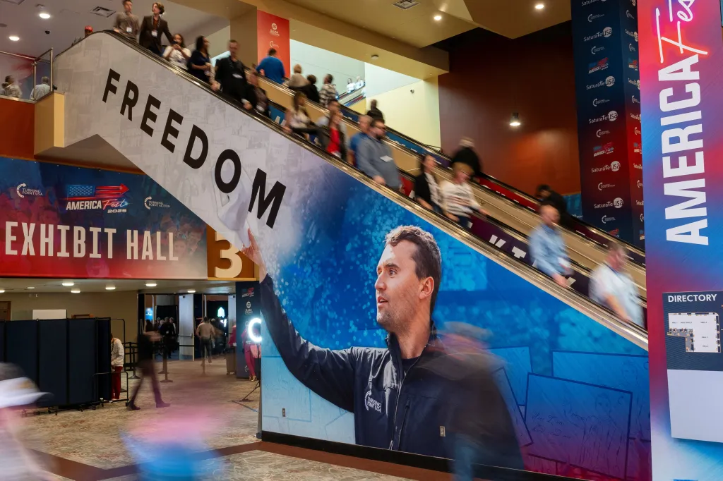 Attendees use an escalator at the AmericaFest conference, with a large