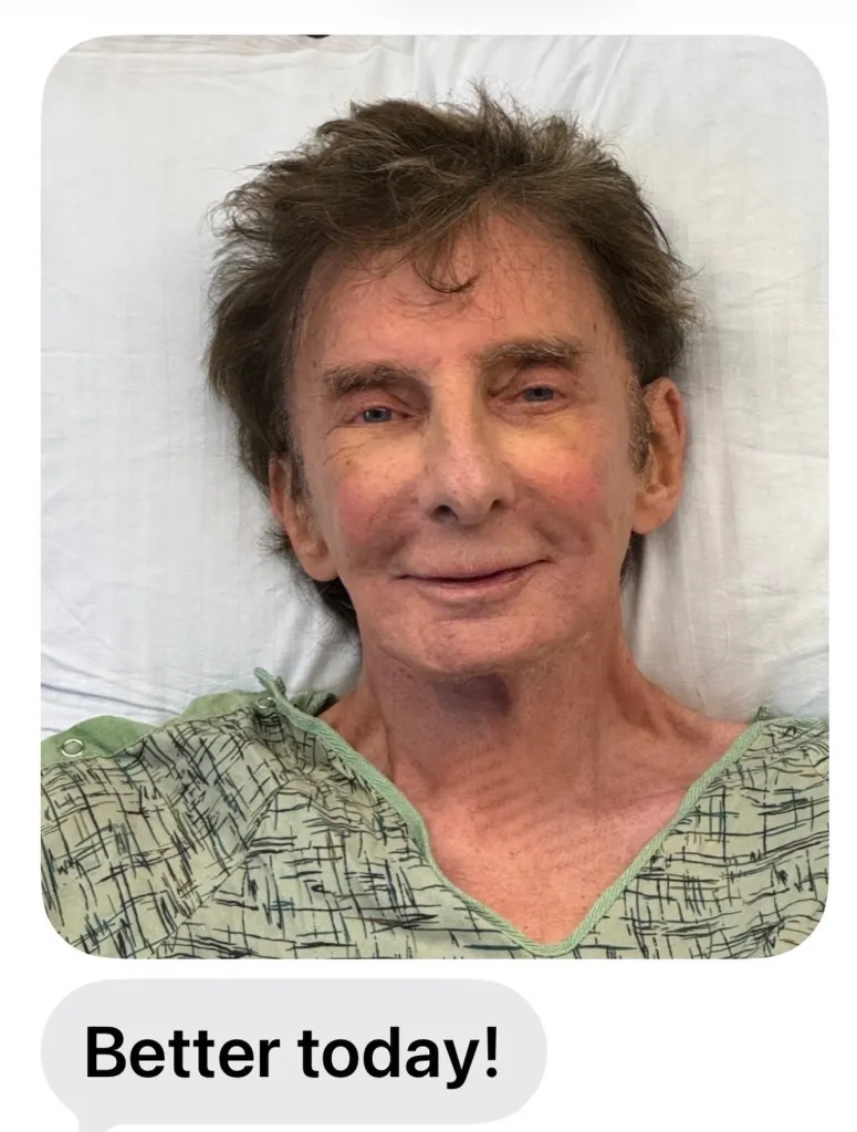 Barry Manilow in a hospital bed, smiling with the text