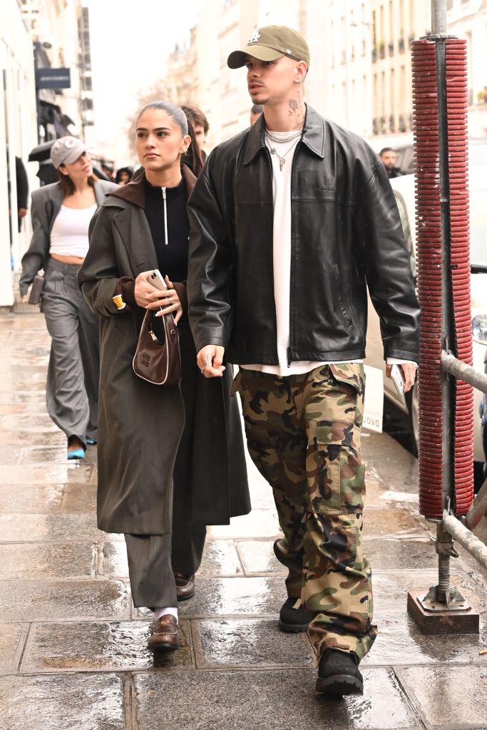 Romeo Beckham and Kim Turnbull walking down a street in Paris.