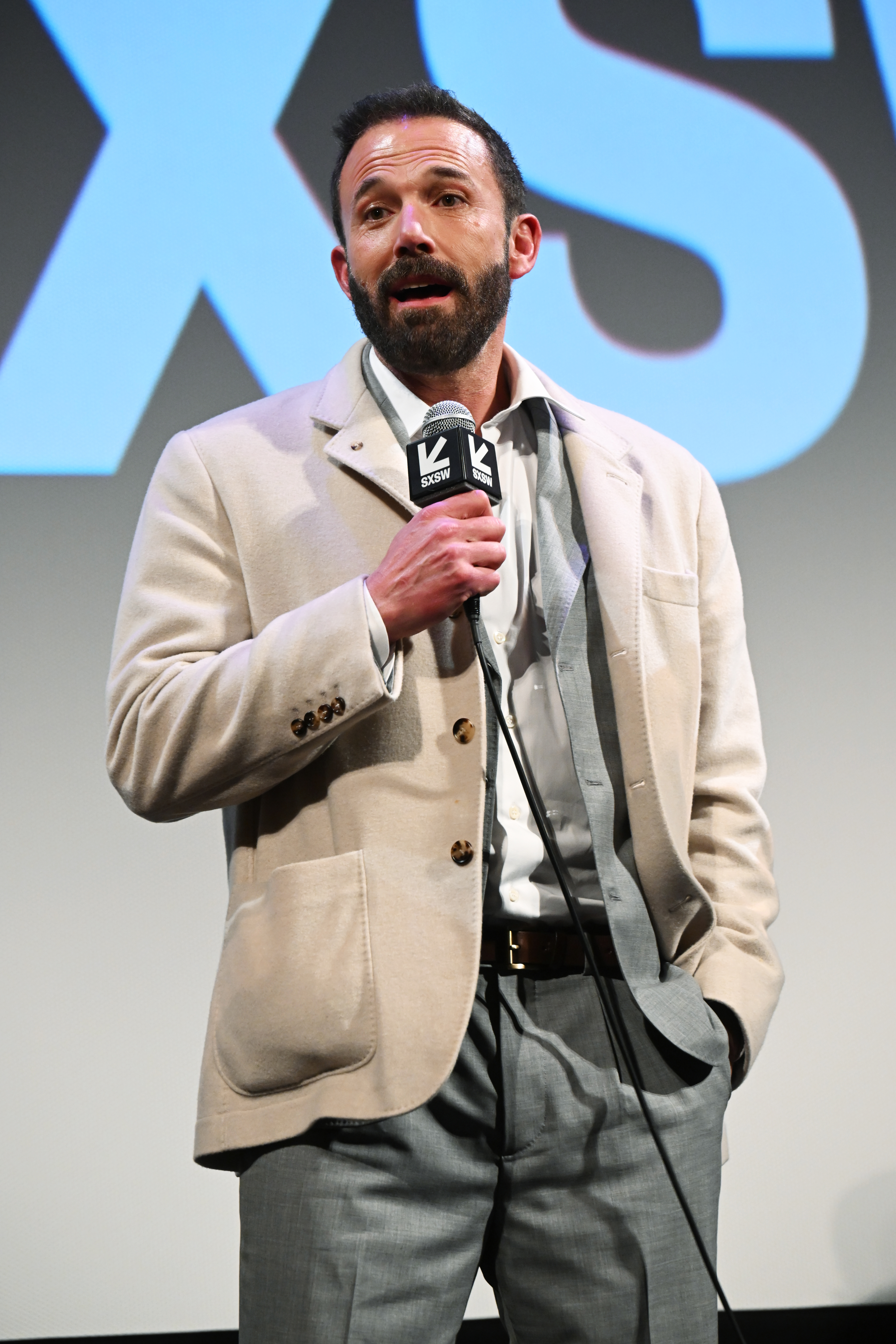 Ben Affleck speaks into a microphone at 