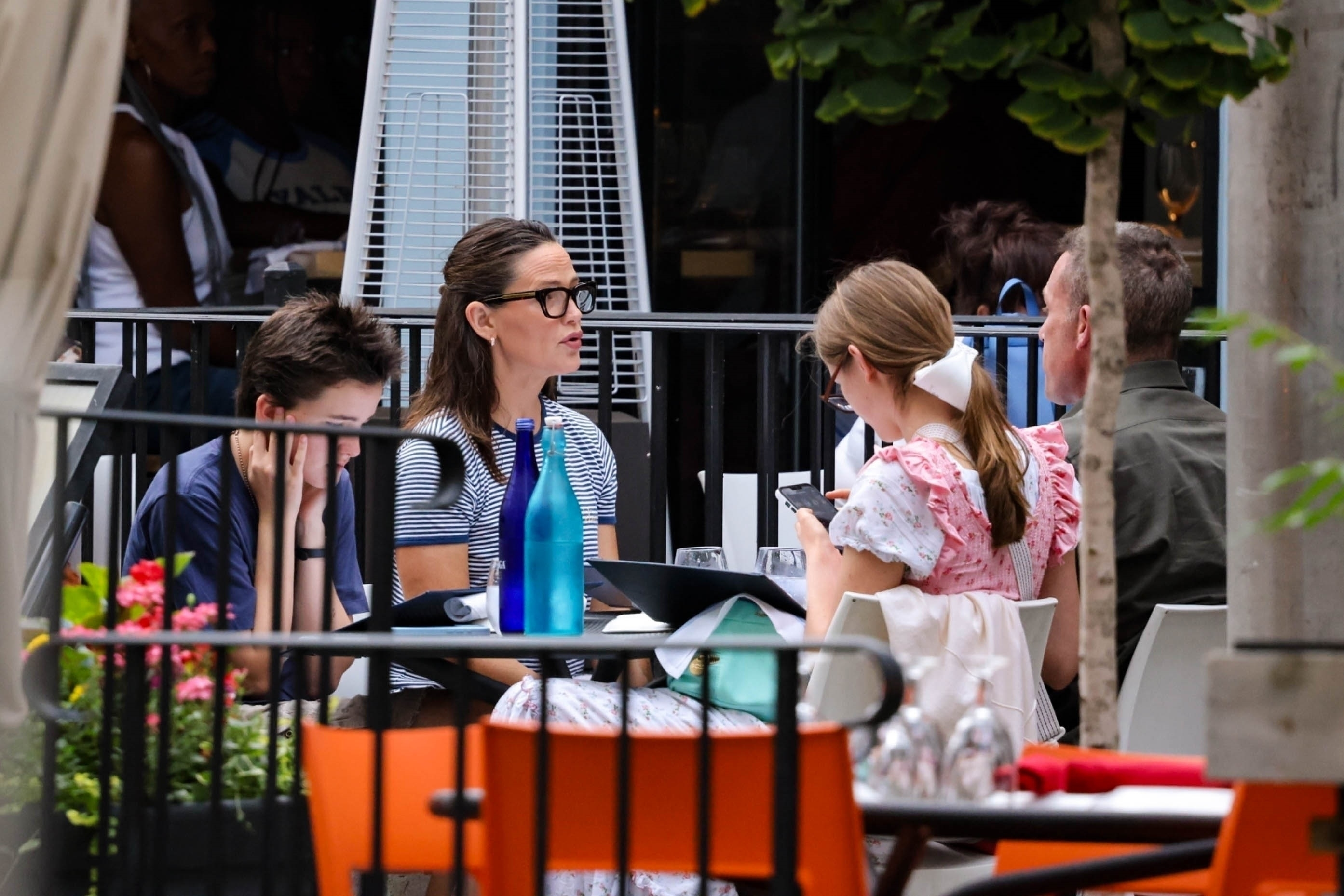 Jennifer Garner and her children, Violet and Fin, dining outdoors at a restaurant.