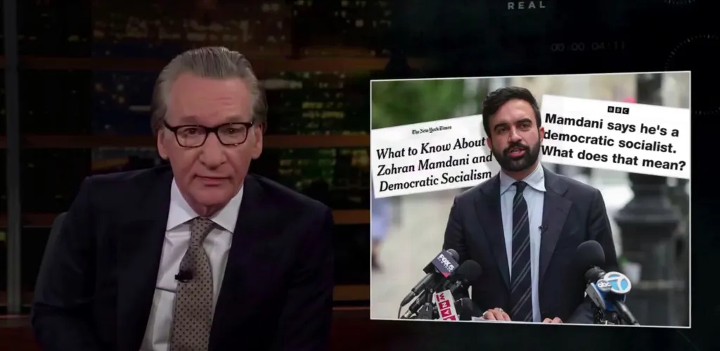 Bill Maher on TV discussing Zohran Mamdani and Democratic Socialism, with news headlines shown on screen.