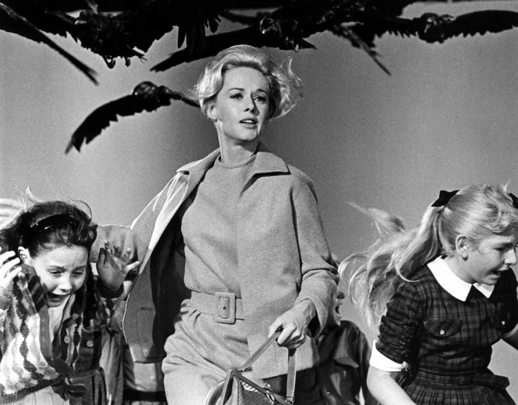 Tippi Hedren, central, with two children, fleeing from a bird attack in the film 