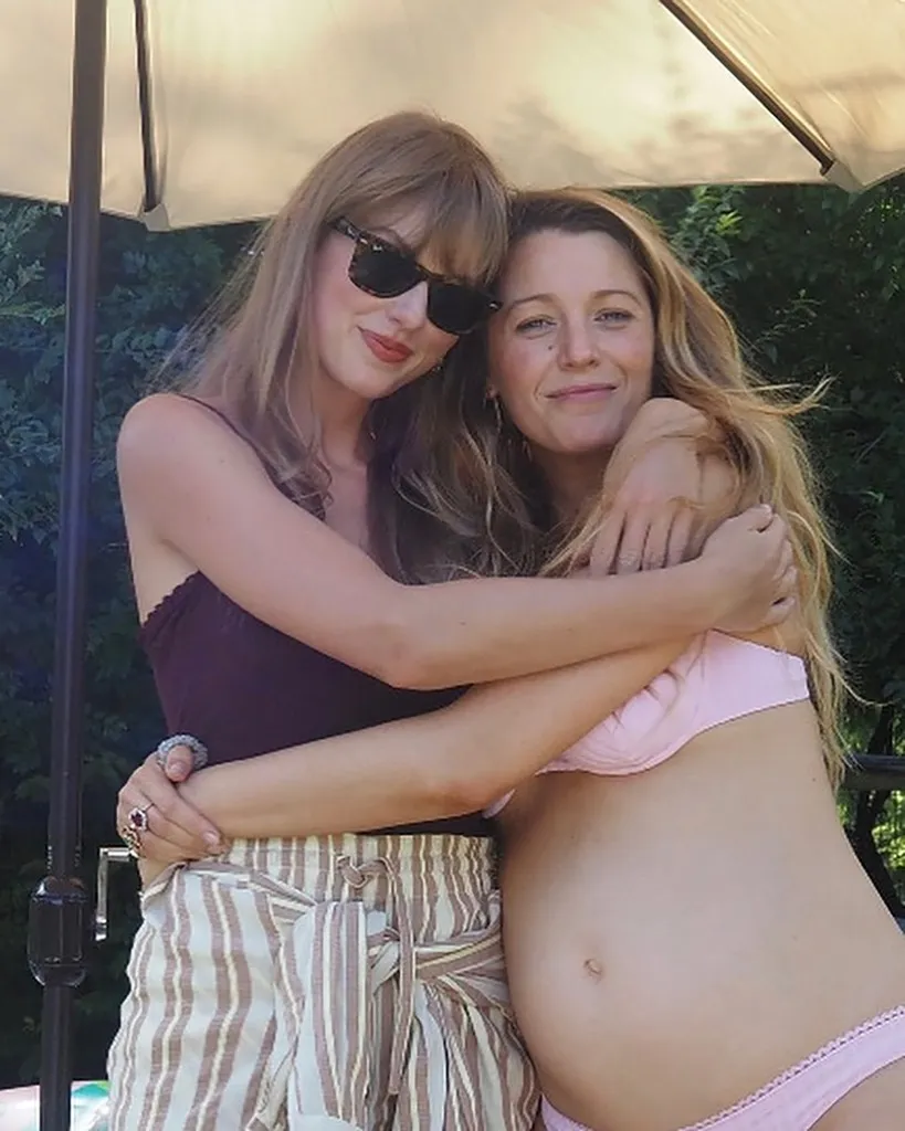 Taylor Swift in sunglasses hugging a pregnant Blake Lively.