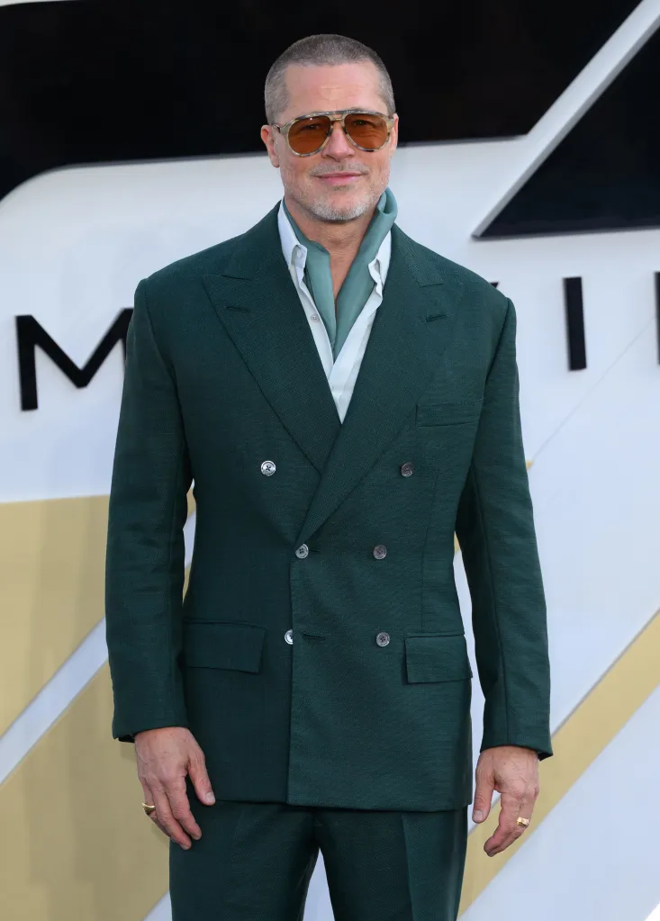 Brad Pitt in a green suit, light blue scarf, and sunglasses.