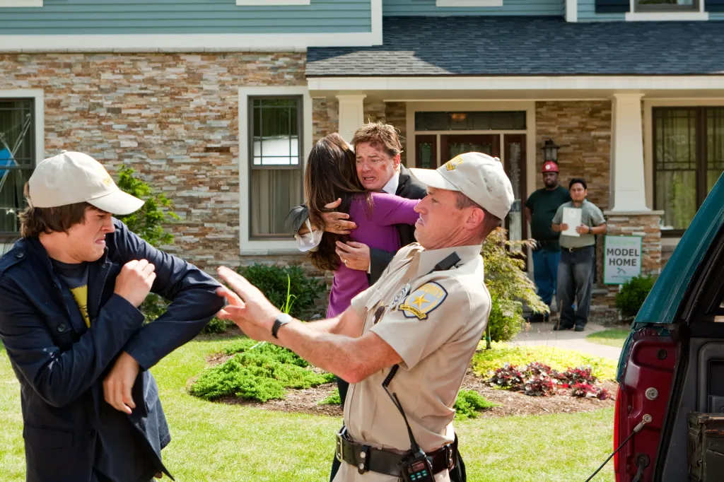 Brendan Fraser as Dan Sanders hugging a woman while being held back by a security guard, with Matt Prokop and other security guards in the background, from the film Furry Vengeance.