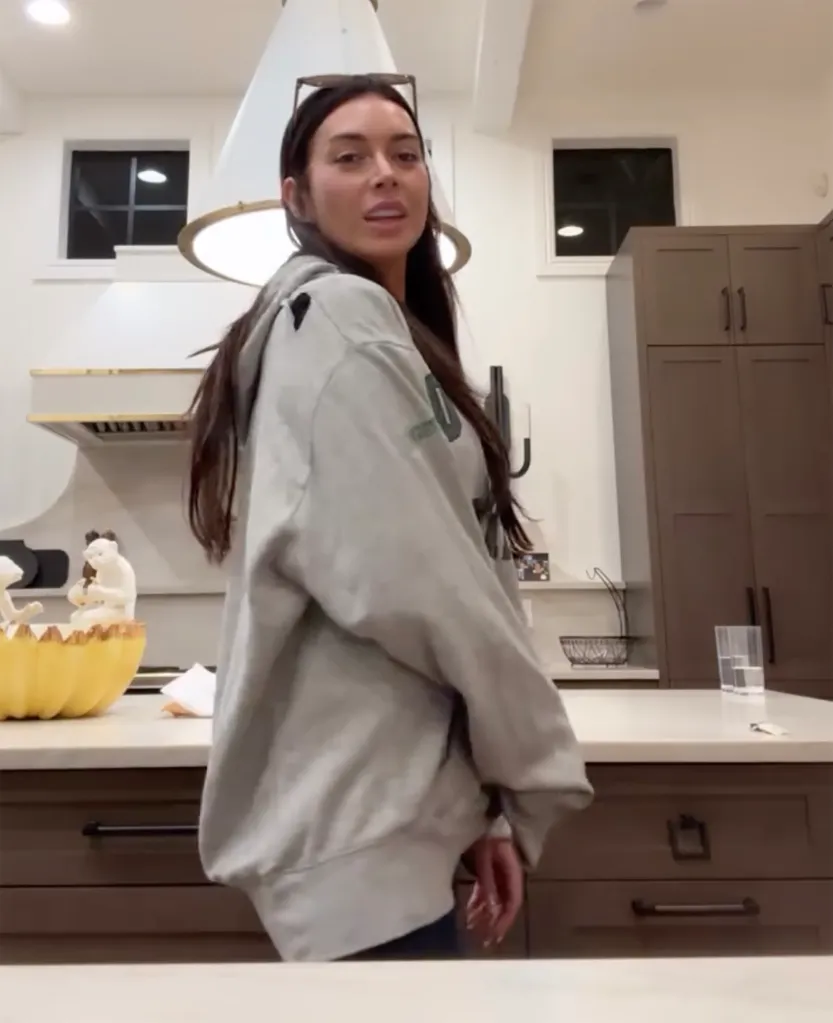 Brianna Chickenfry in a light gray hoodie standing in a kitchen.