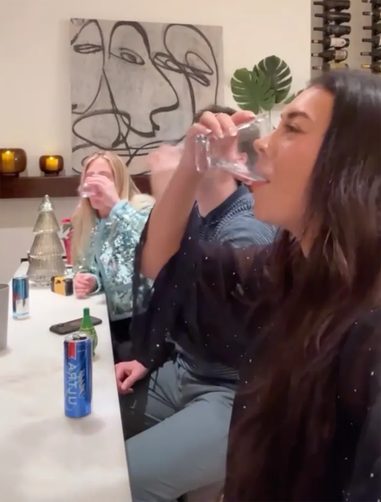 Brianna Chickenfry drinking from a glass in a celebratory setting with friends.