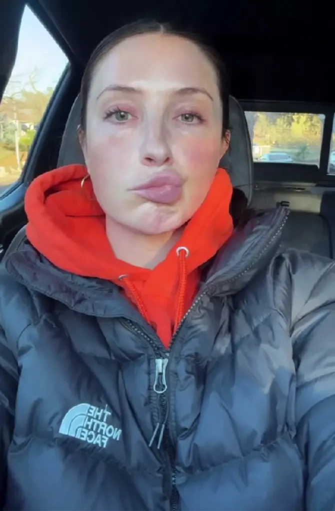Bristol Palin in a car, wearing an orange hoodie and black puffer jacket, with a pursed-lip expression.
