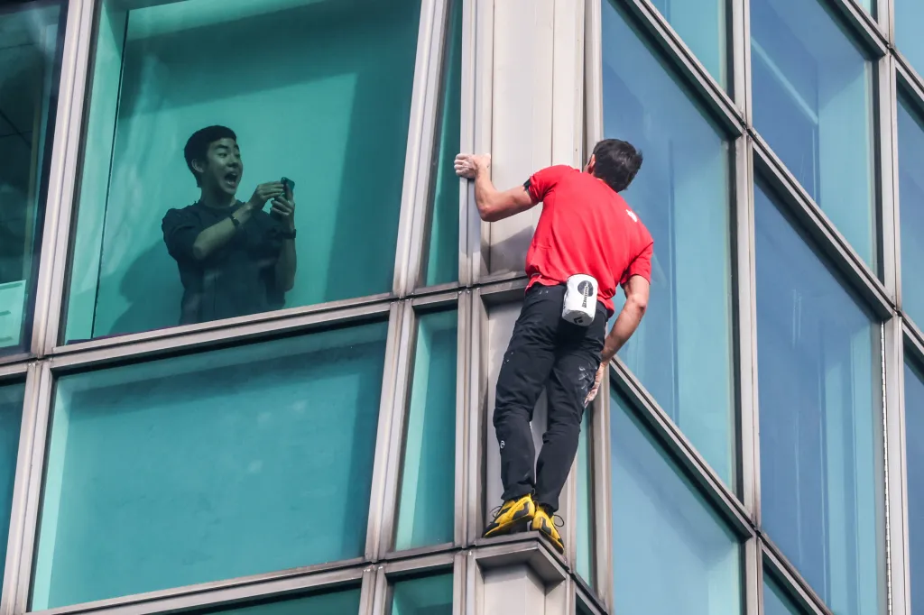 A building occupant uses his phone to record US rock climber Alex Honnold climbing the Taipei 101 building.