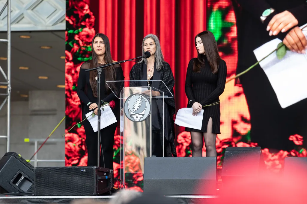 Bob Weir's wife Natascha Weir speaks alongside his daughters Chloe Weir and Monet Weir at the public memorial.