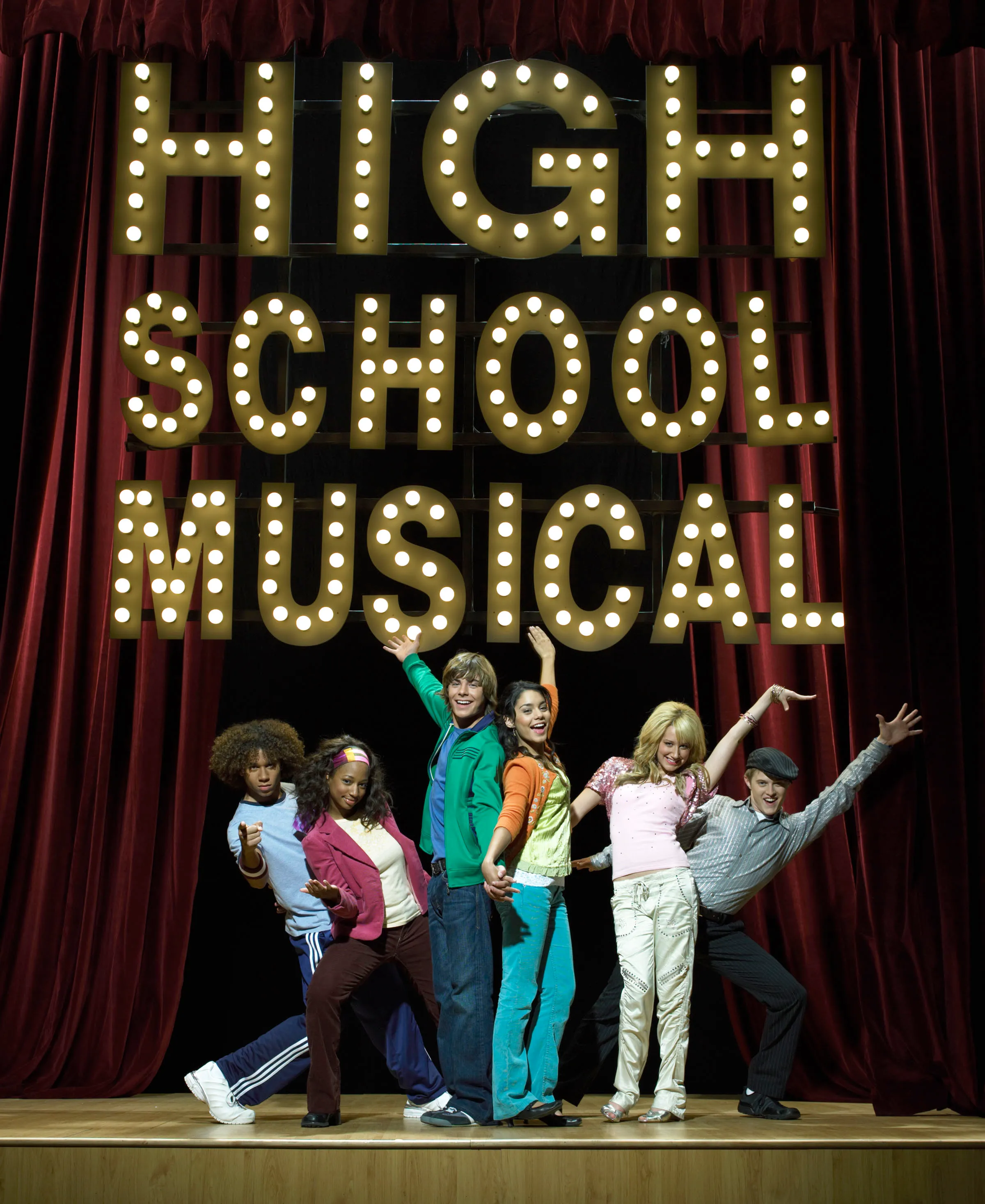 The cast of High School Musical posing on a stage with a