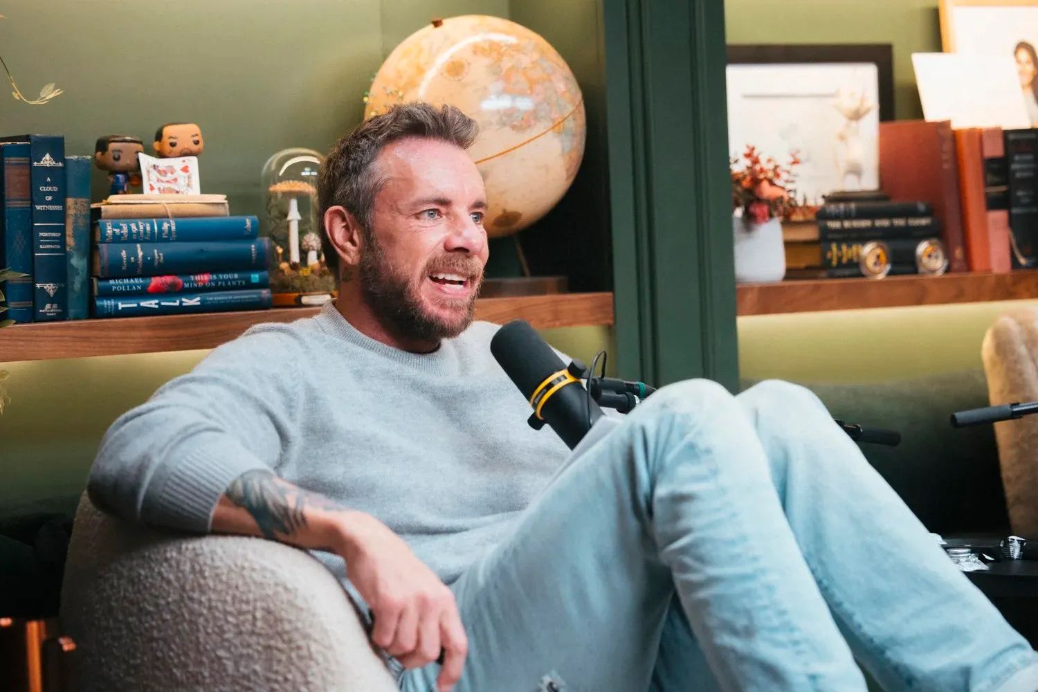 Dax Shepard sitting and talking on his podcast.