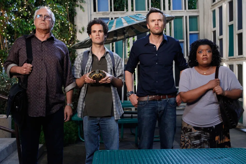 Four people, including Chevy Chase, David Neher, Joel McHale, and Yvette Nicole Brown, standing and looking up from their show Community.