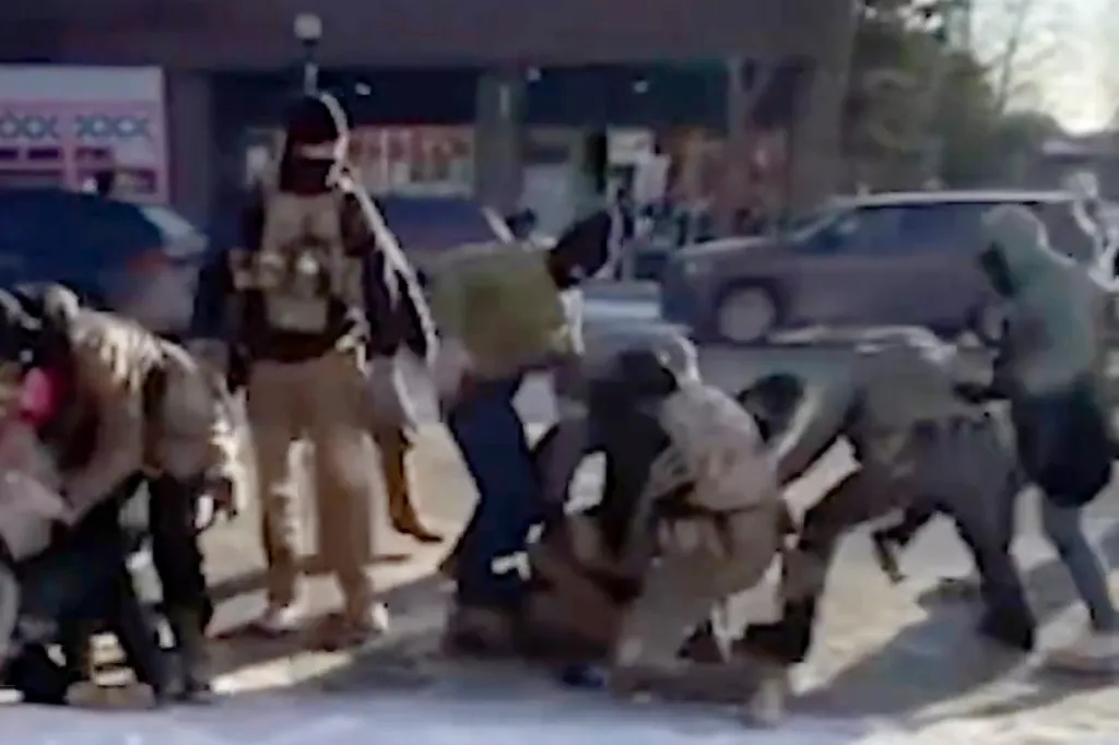 Federal agents restraining a man on the ground in Minneapolis.