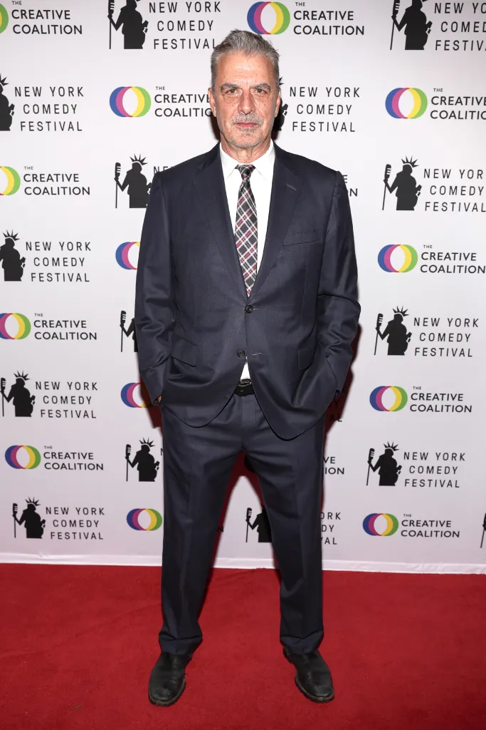 Chris Noth on a red carpet in front of a step-and-repeat banner for The Creative Coalition and New York Comedy Festival.