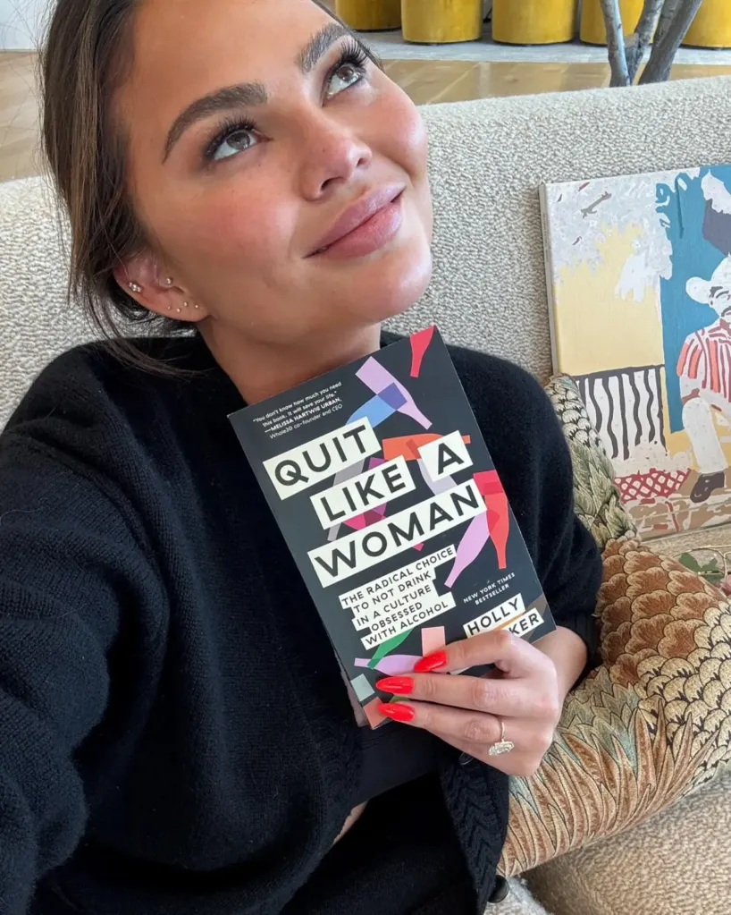 Chrissy Teigen holding the book 