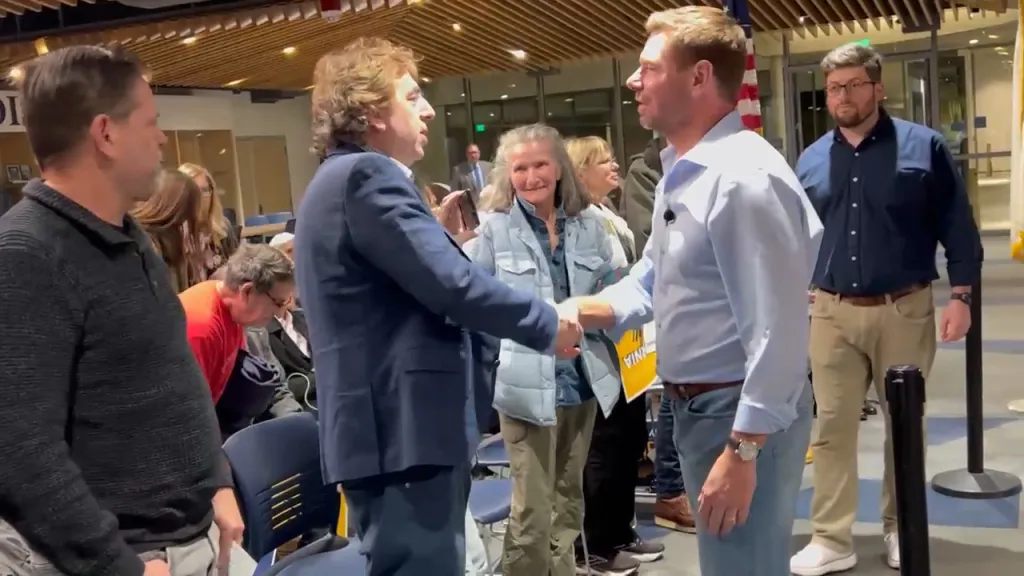 Conservative activist Joel Gilbert shakes hands with Representative Eric Swalwell at a town hall.