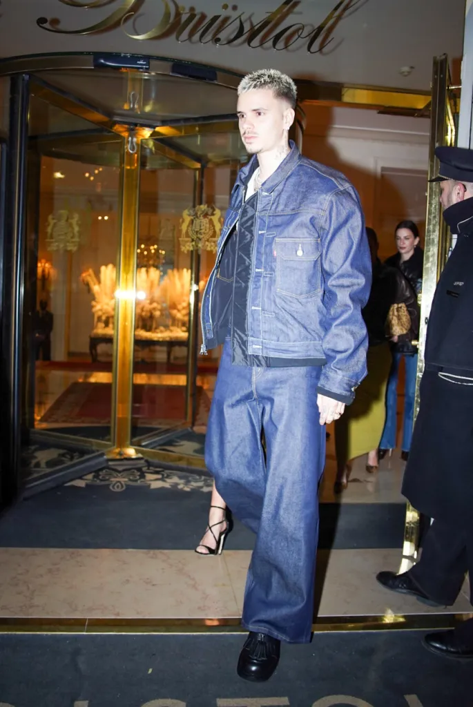 Romeo Beckham in a coordinated denim outfit, including an oversized denim jacket and wide-leg jeans, entering Restaurant Kaspia in Paris.