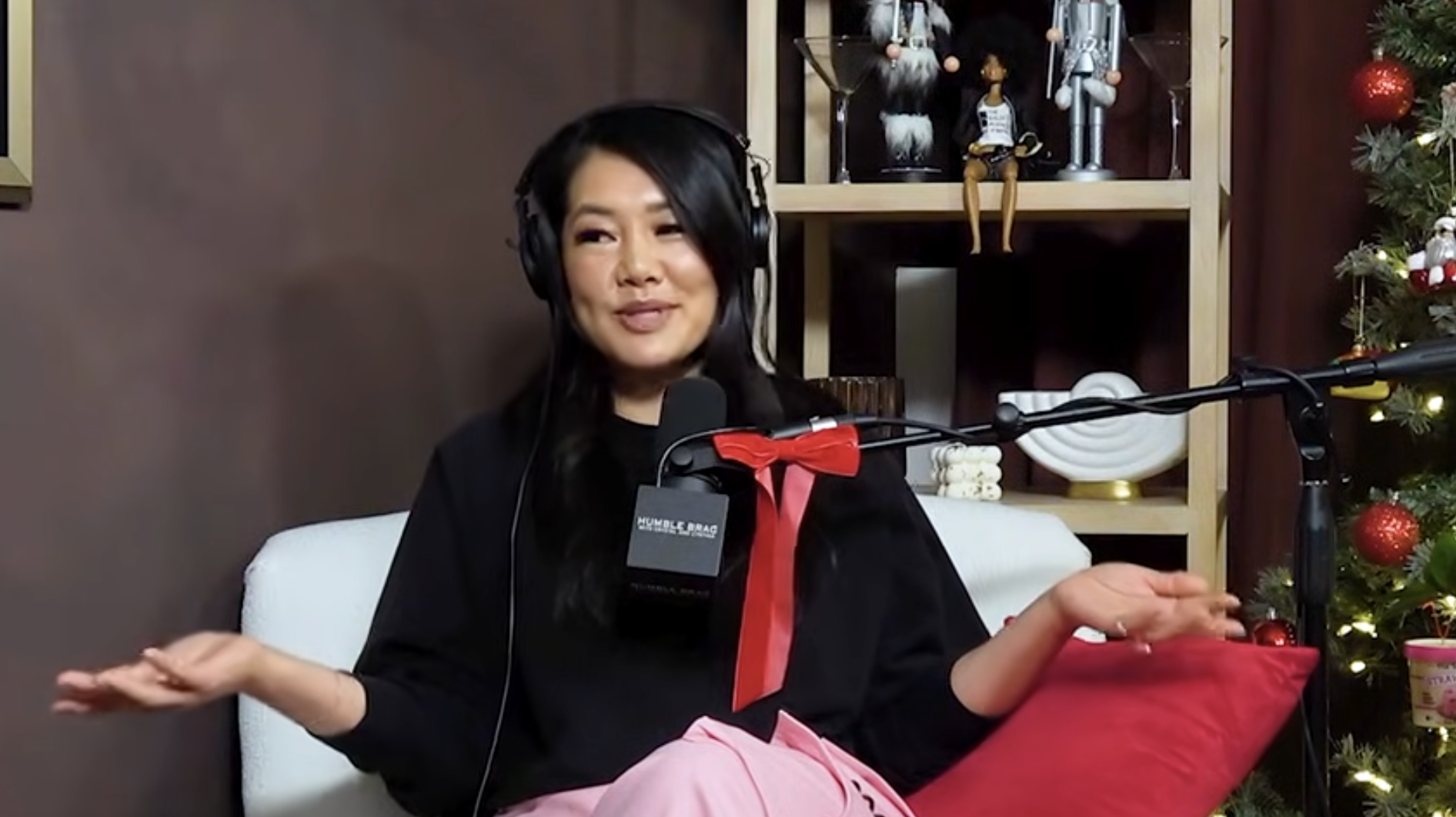 Crystal Kung Minkoff speaking into a microphone with headphones on during a podcast.