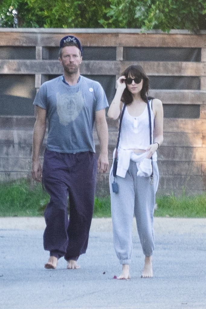 Chris Martin and Dakota Johnson walking barefoot.