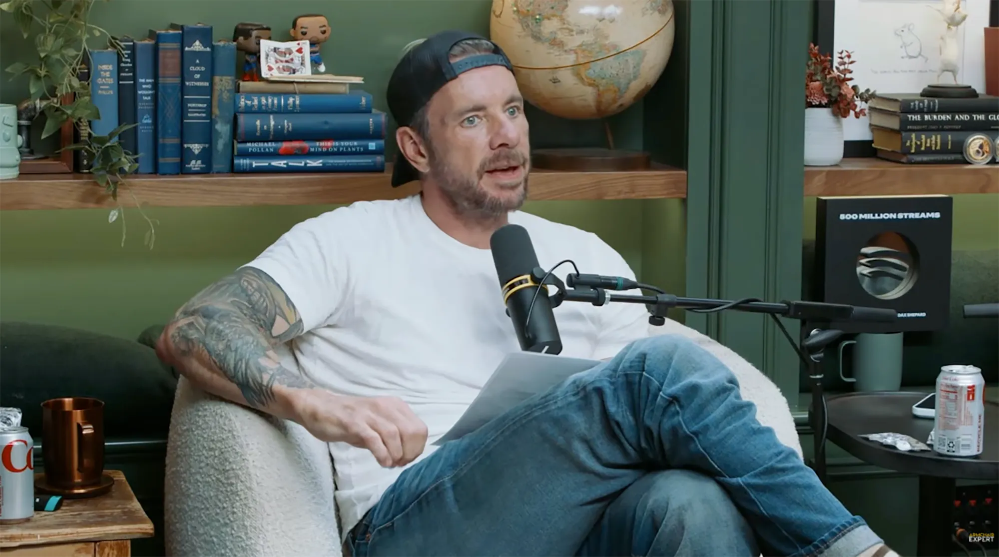 Dax Shepard speaking into a microphone while seated.