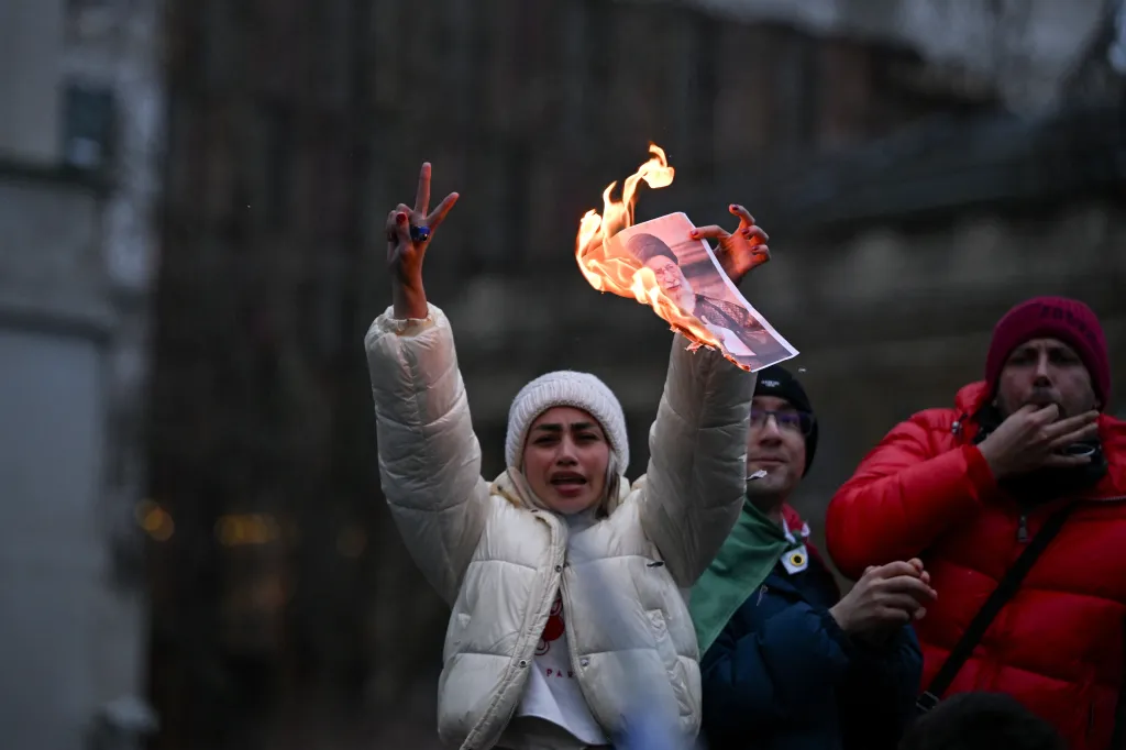A protester holds up a burning photo of Khamenei outside Downing Street in London, UK. 