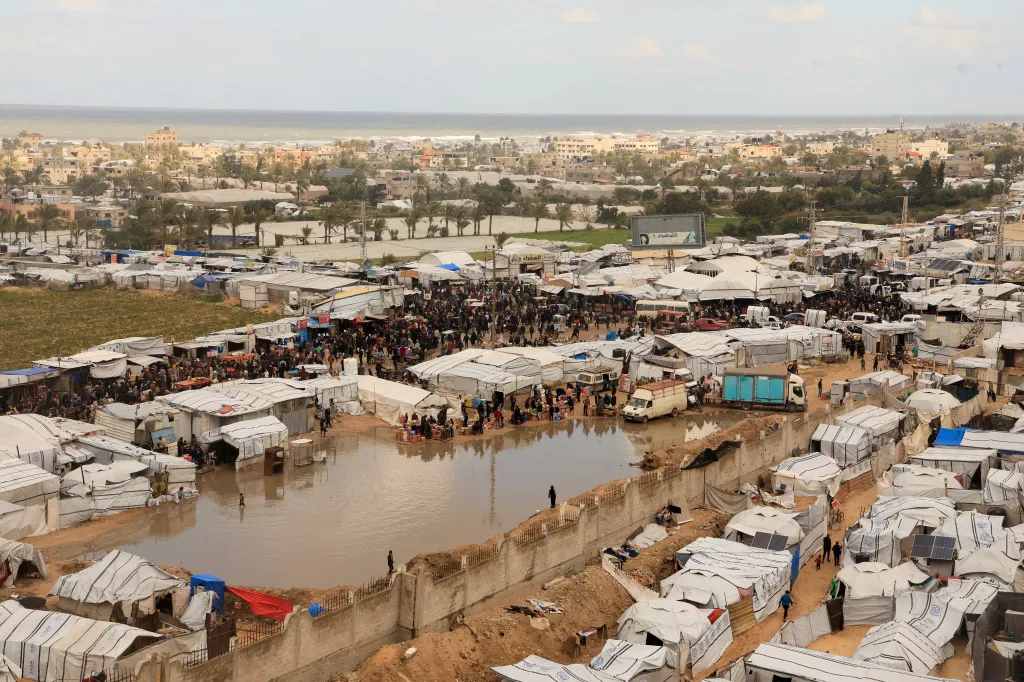 Displaced Palestinians shelter at a tent camp in Khan Younis, with sections of the camp flooded.