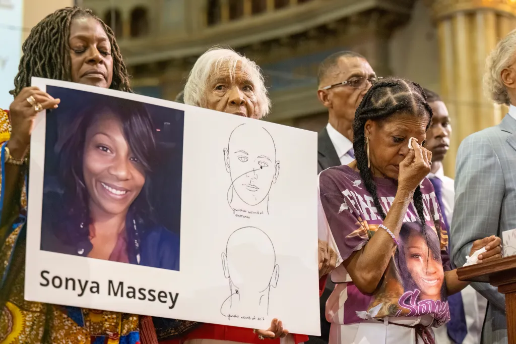 Donna Massey, center right, wipes tears from her face during a press conference over the shooting death of her daughter, Sonya.