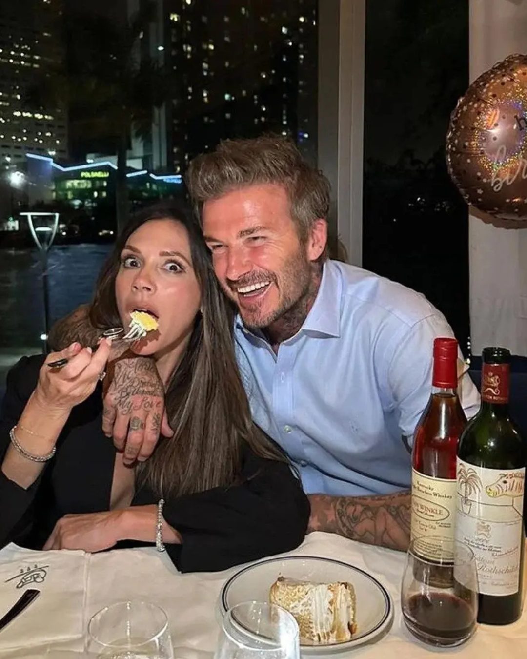 Victoria and David Beckham eating cake at a restaurant.
