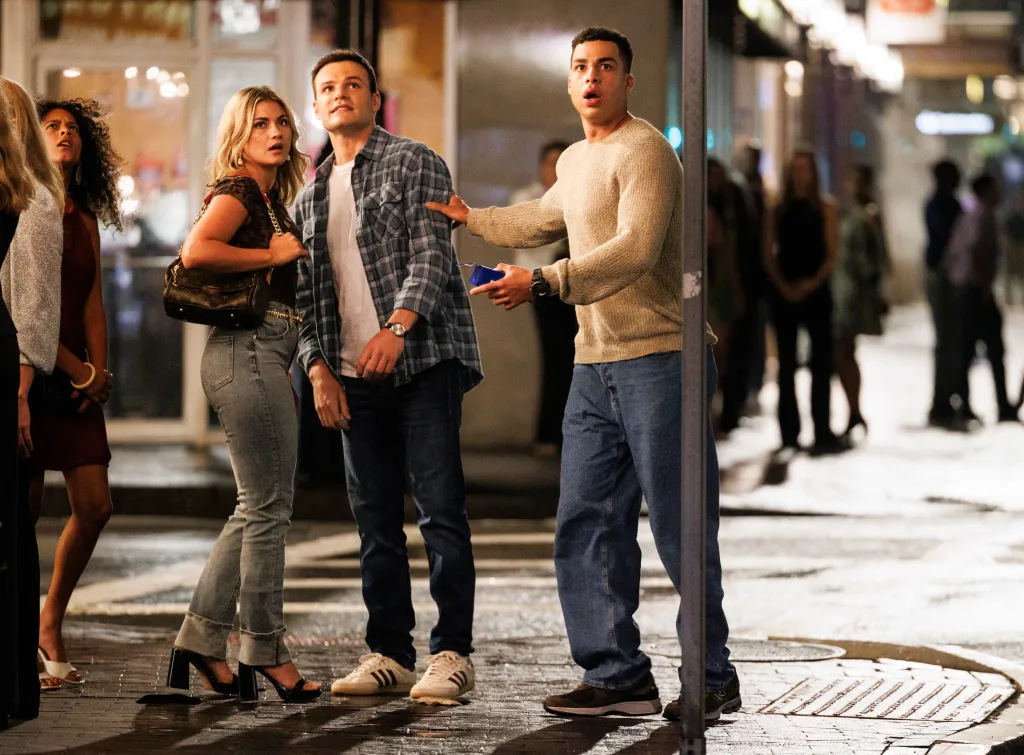Mika Amonsen as Sean Reagan and Marcus Scribner as Jonah Silver looking surprised and concerned on a wet city street at night.