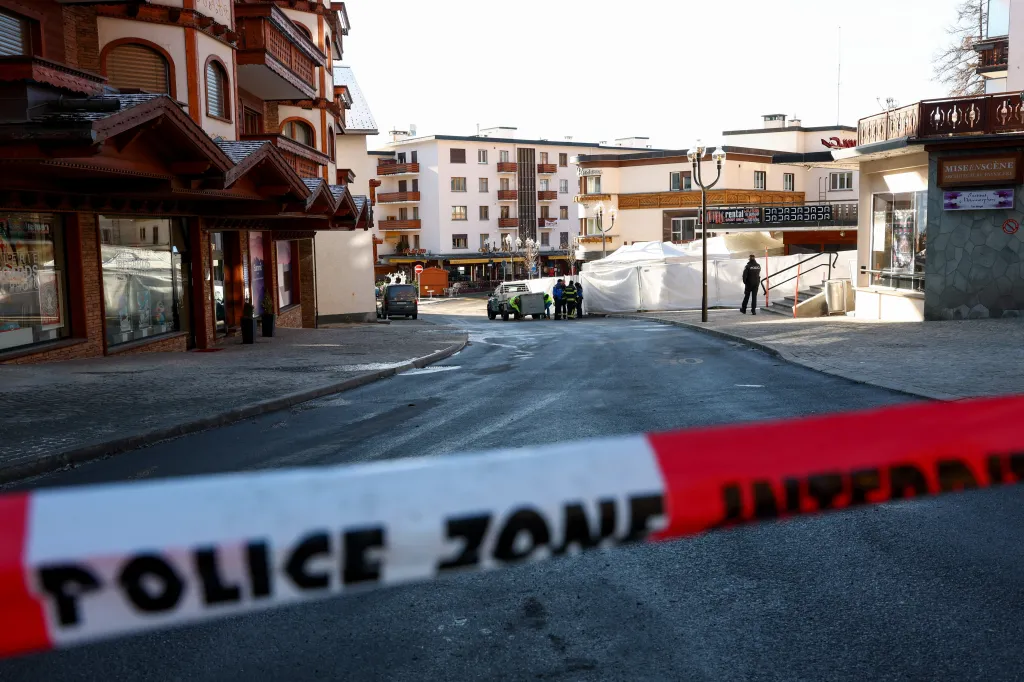 Police tape blocks off a street near the Le Constellation bar, with emergency personnel and white tents visible in the background.
