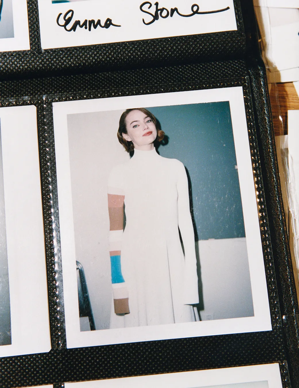 Emma Stone posing for W Magazine in a white dress, photographed by Tyrone Lebon.