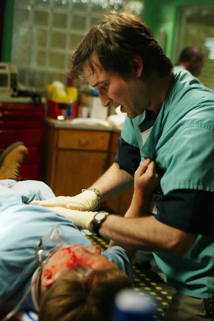 Noah Wyle in costume of a green scrubs.
