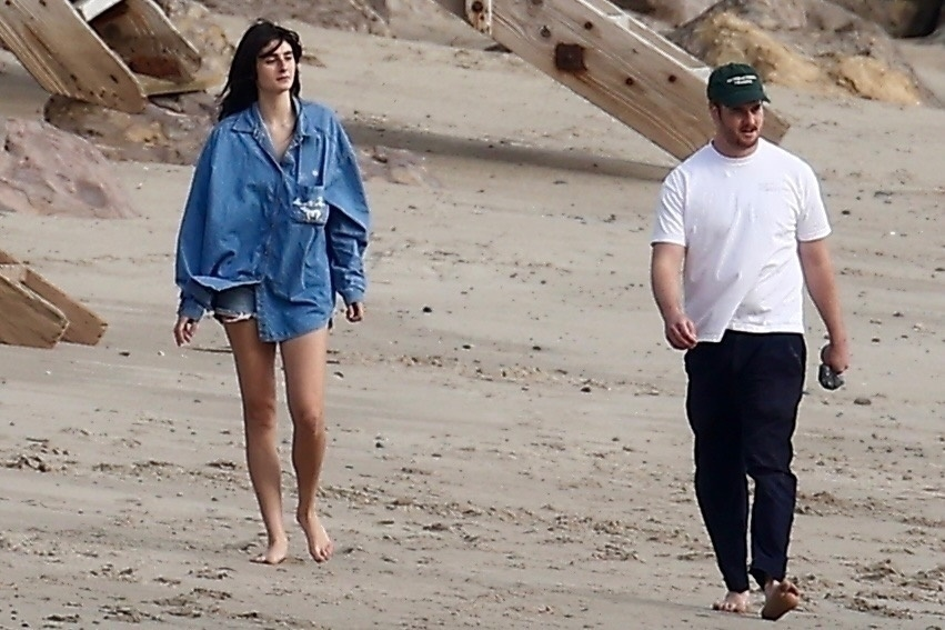 Romy Reiner and Alex Siliberg walking barefoot on Malibu beach.