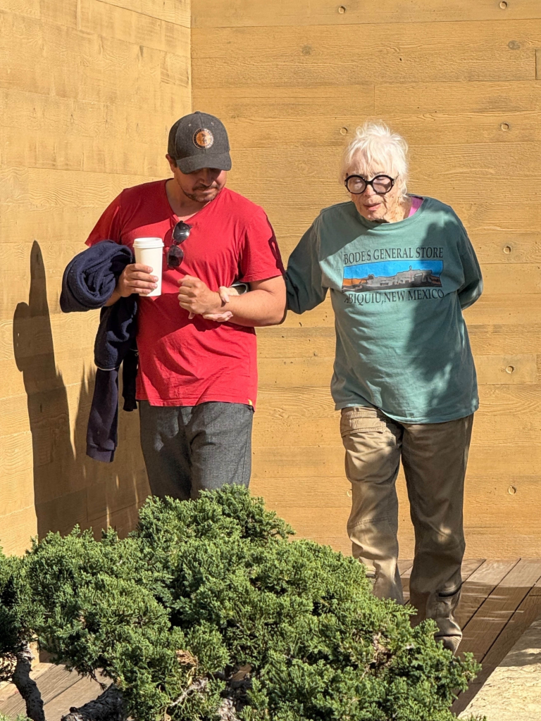 Shirley MacLaine being assisted by a friend after lunch.
