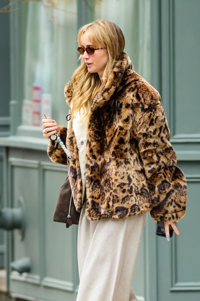 Jennifer Lawrence in a leopard print coat, gray sweatpants, brown purse, and turquoise flats.