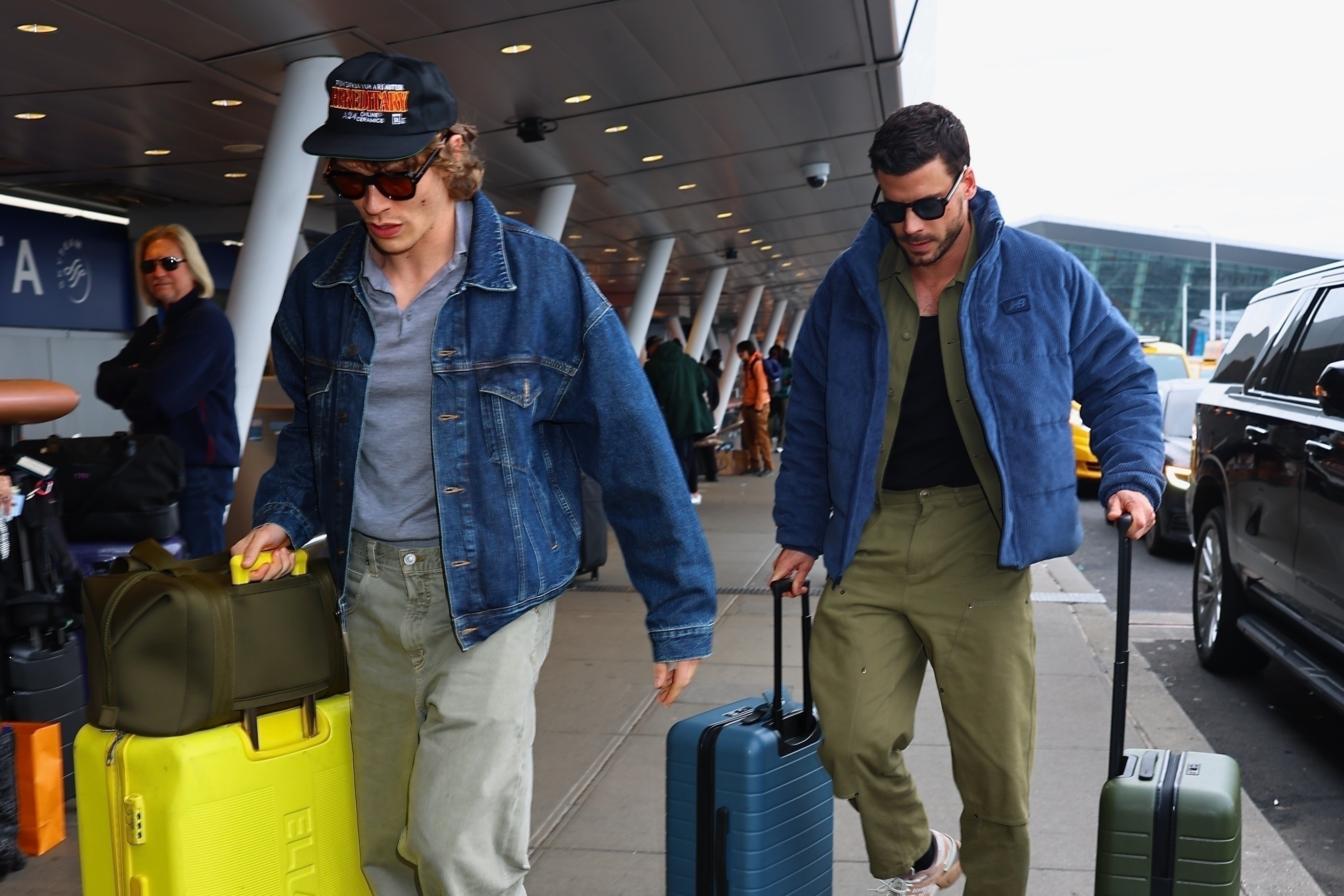 Connor Storrie and François Arnaud walking with their luggage at JFK Airport after their 