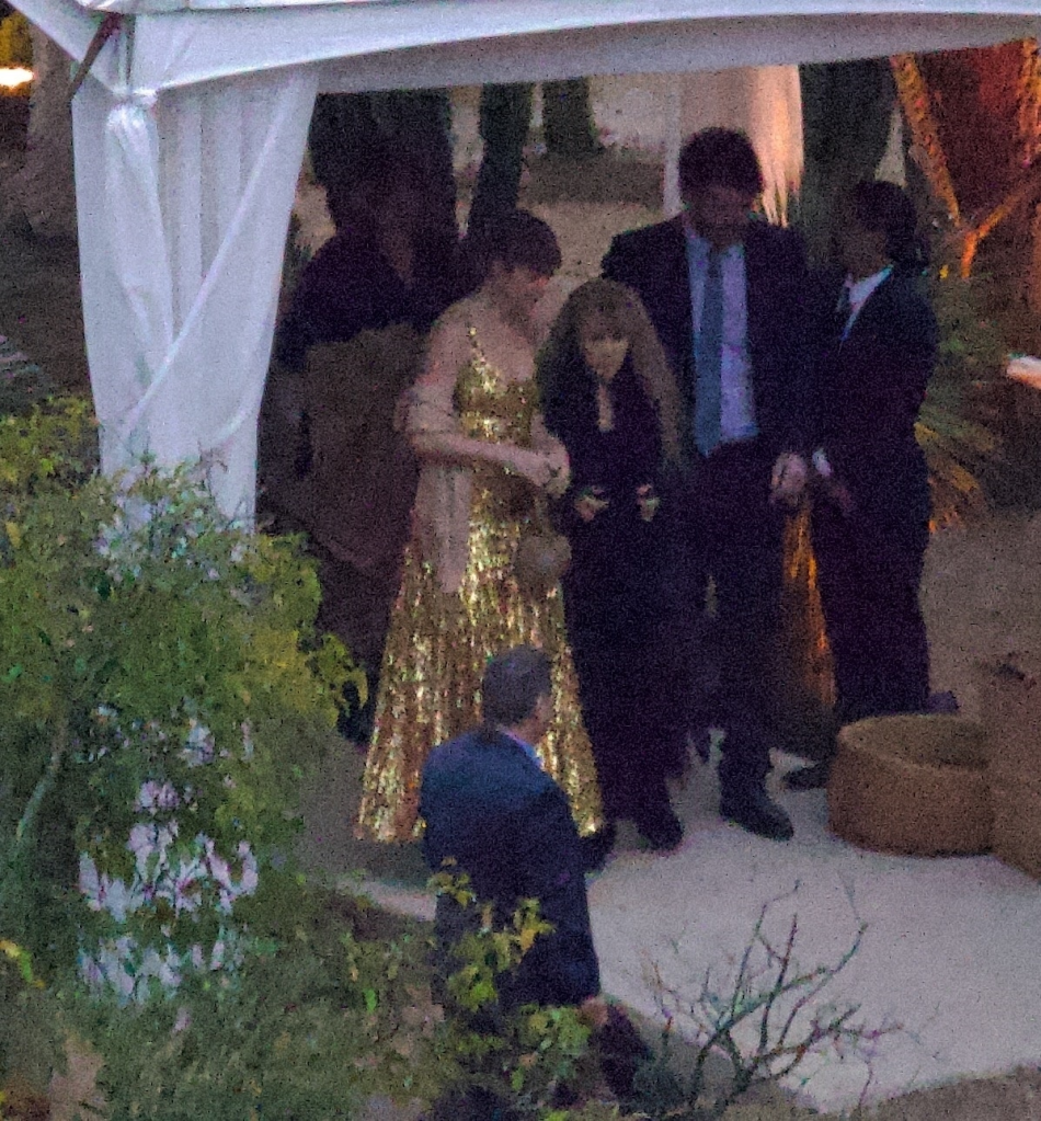 Taylor Swift in a gold dress with Stevie Nicks and Este Haim at a wedding.