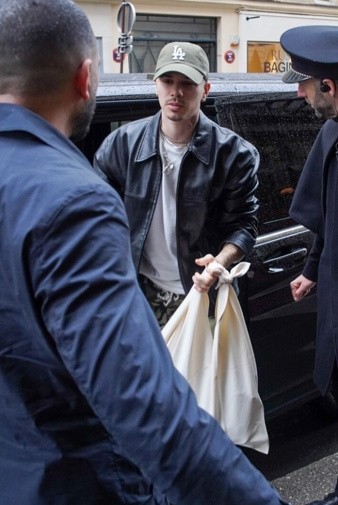 Romeo Beckham carrying bags while arriving at a Paris hotel.