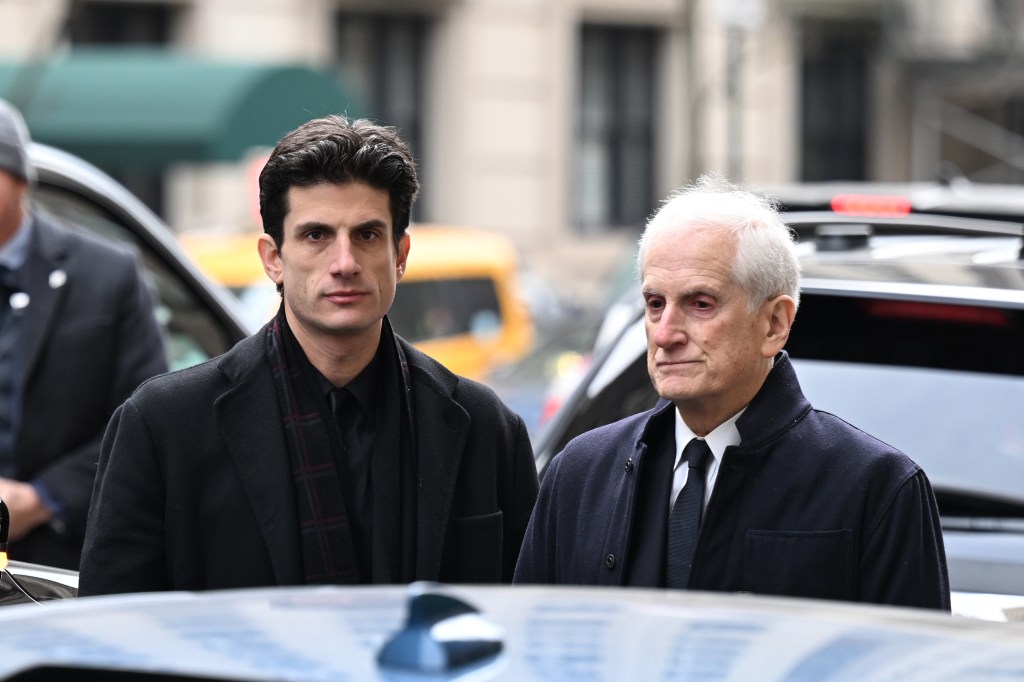 Jack Schlossberg, in ab lack suit, and Edwin Schlossberg, in a black suit and tie and black coat, at Tatiana Schlossberg's funeral.