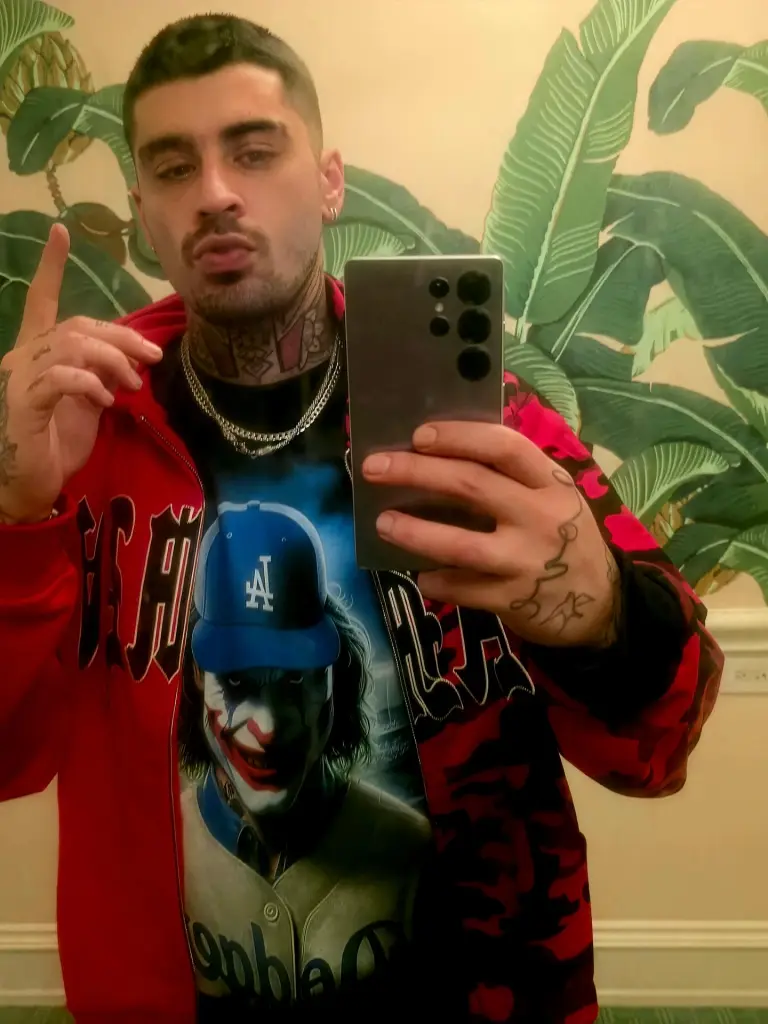 Zayn Malik taking a mirror selfie while holding a Samsung Galaxy S25 Ultra phone.