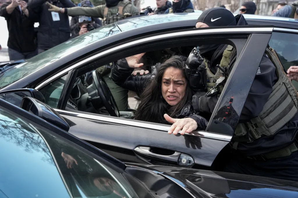 Federal agents grab a woman to drag her away from her car, days after an ICE agent fatally shot Renee Nicole Good, in Minneapolis, Minnesota on January 13, 2026.