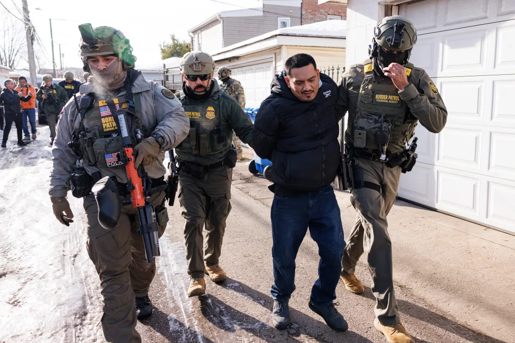 Federal immigration enforcement agents detain an individual near West 27th Street and South Ridgeway Avenue in the Little Village neighborhood of Chicago, Tuesday, Dec. 16, 2025.