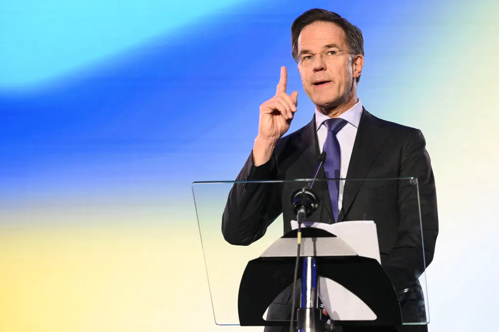NATO Secretary General Mark Rutte speaking at a podium with his right index finger raised.